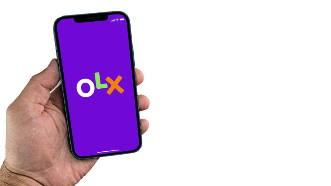 Celular na mão com app da OLX na tela inicial