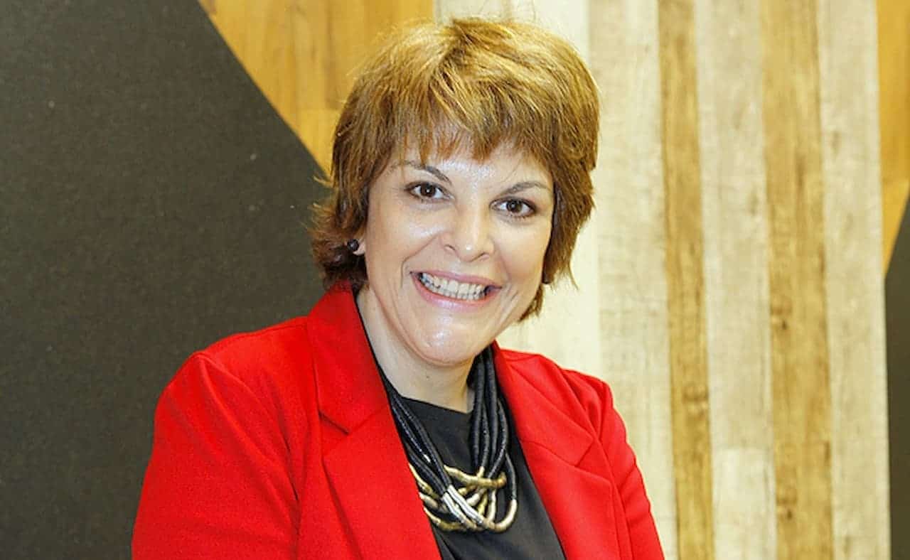 Foto de Leonor Corrêa, irmã de Faustão com blusa vermelha e sorrindo