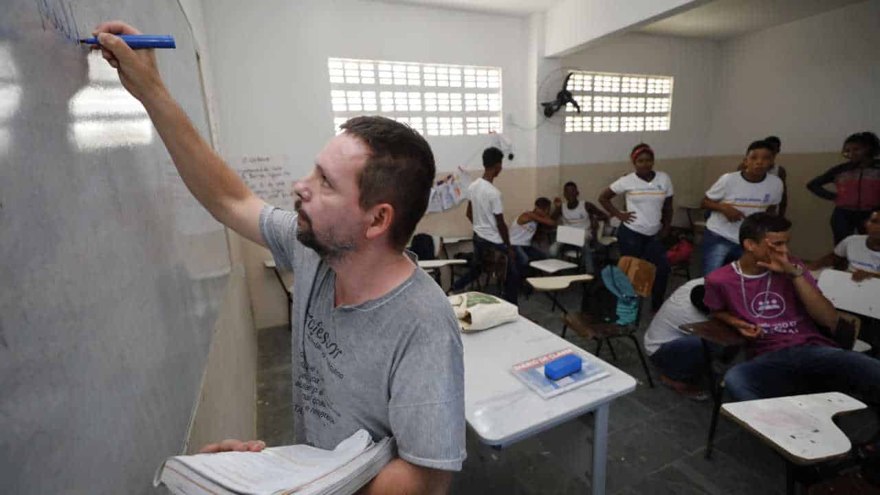 professor dando aula para uma turma do ensino médio de uma escola pública