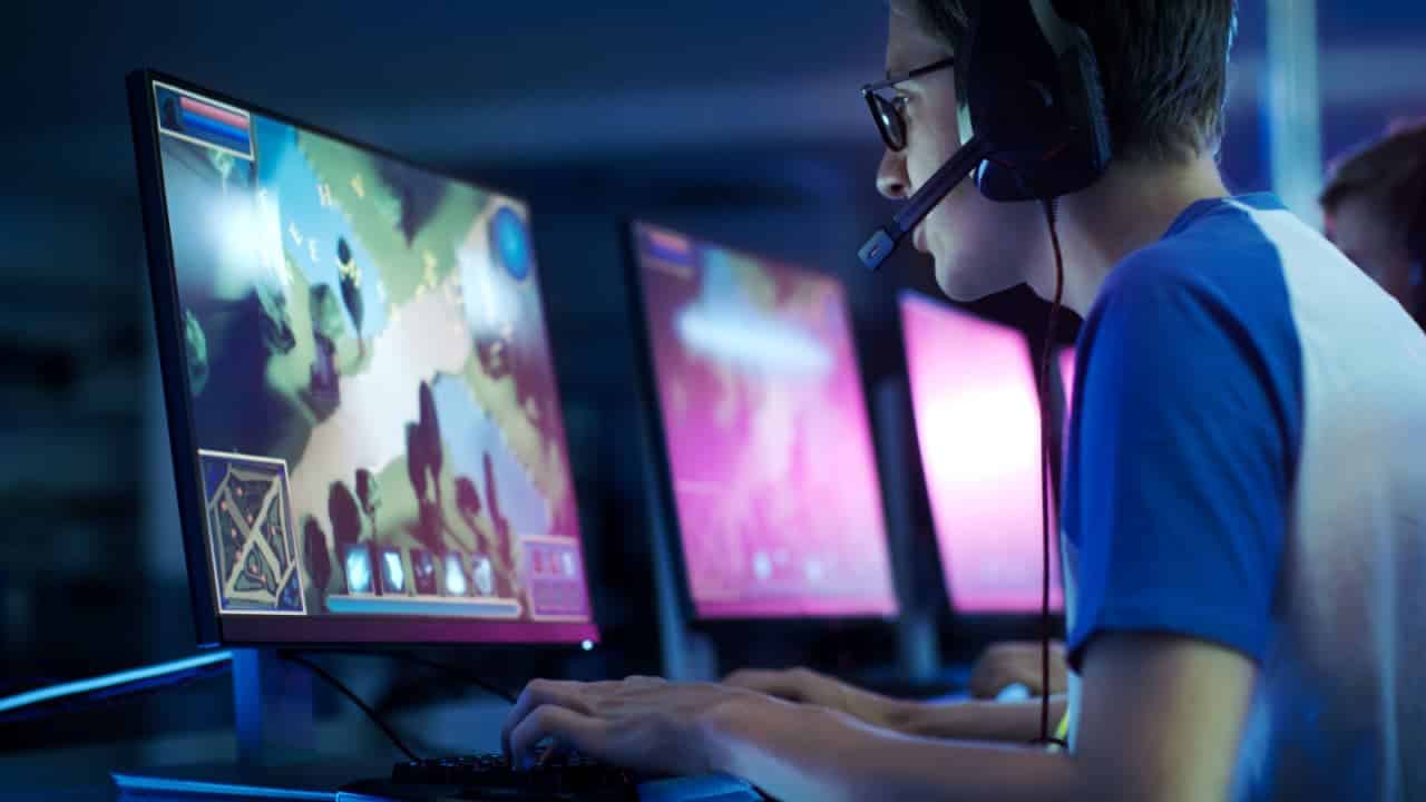 Jogador profissional de eSport jogando em MMORPG/Estratégia Competitiva em um Torneio Cyber Games. Ele conversa por microfone no computador.