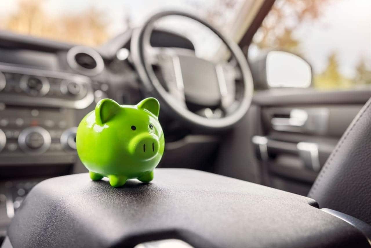 Imagem de um porquinho de dinheiro verde em um carro