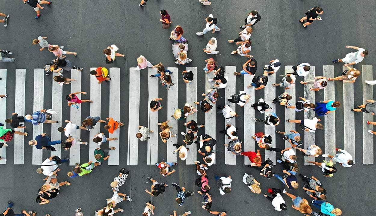 Imagem de pessoas atravessando a rua, visto de cima.