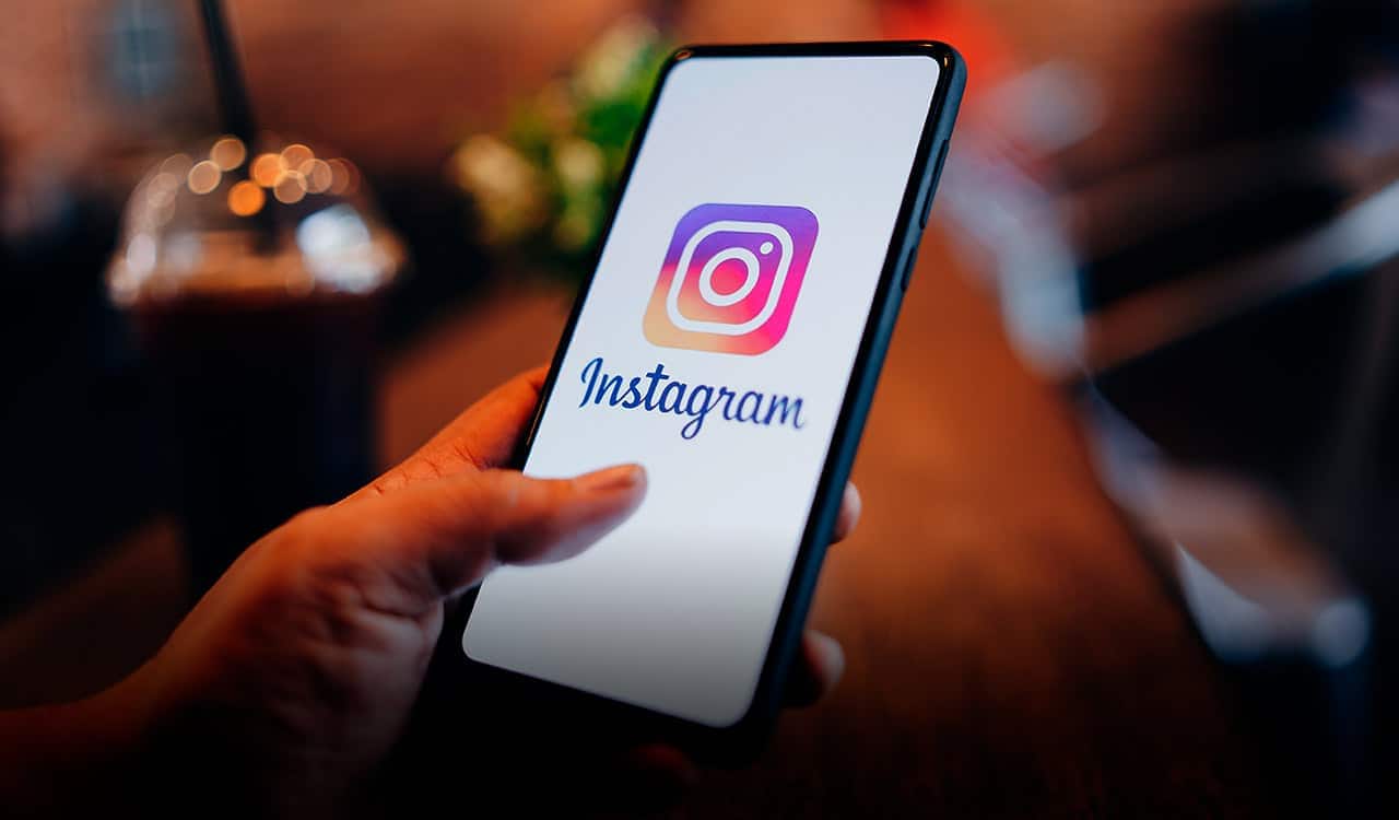 Mão segurando celular com Instagram