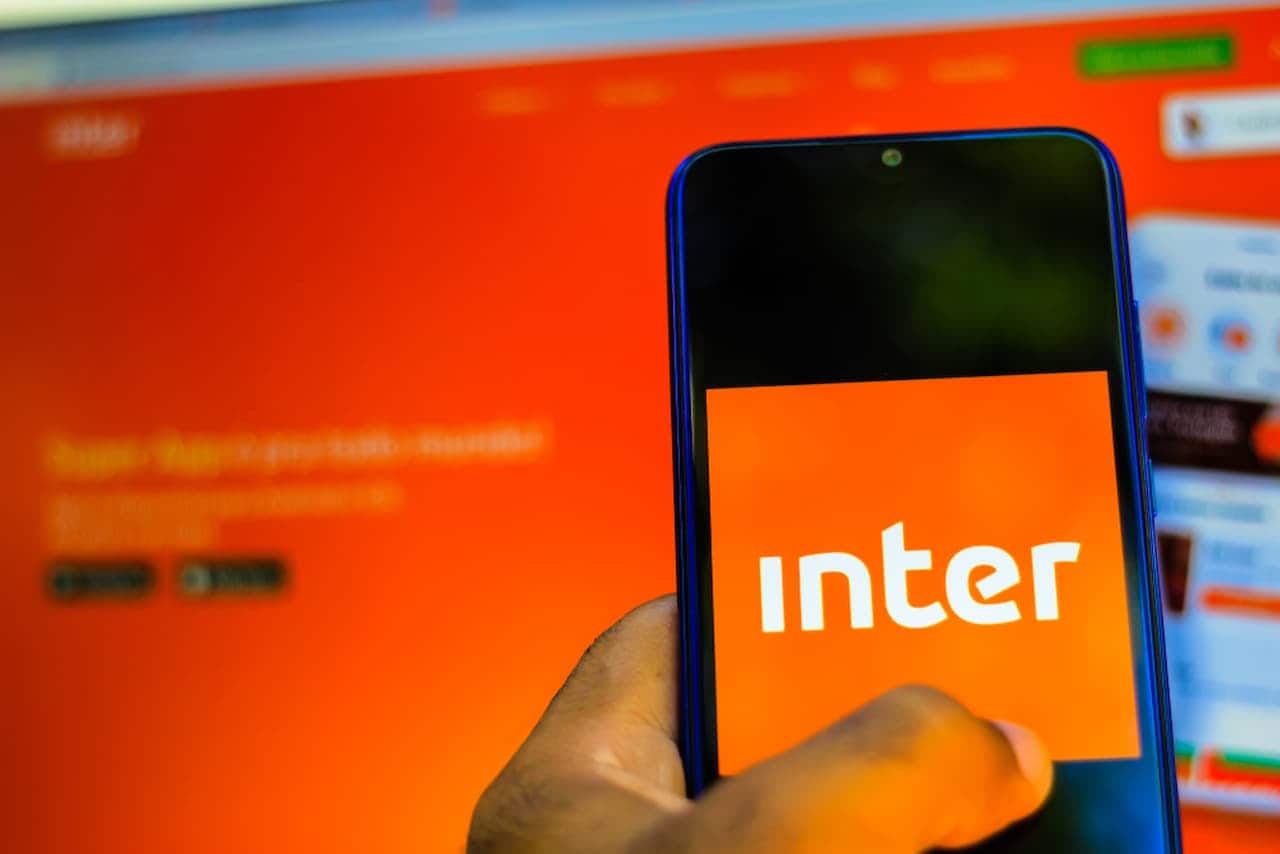 Mão segurando celular com app do Inter aberto