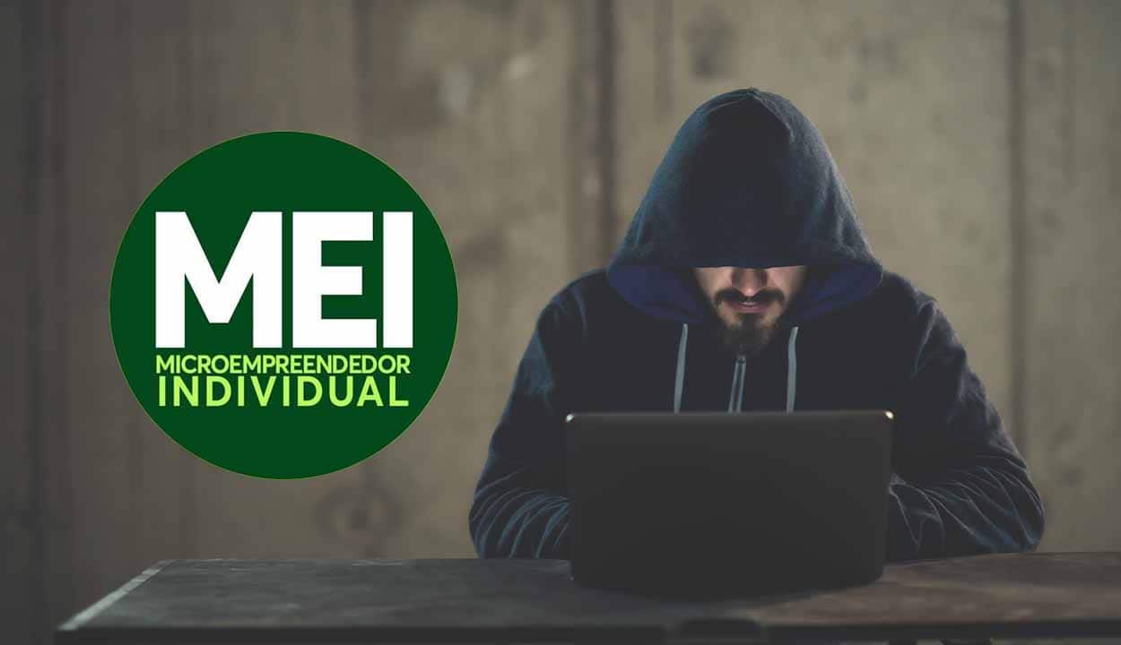 Pessoa encapuzada suspeita usando computador. Ao lado, símbolo do MEIs.
