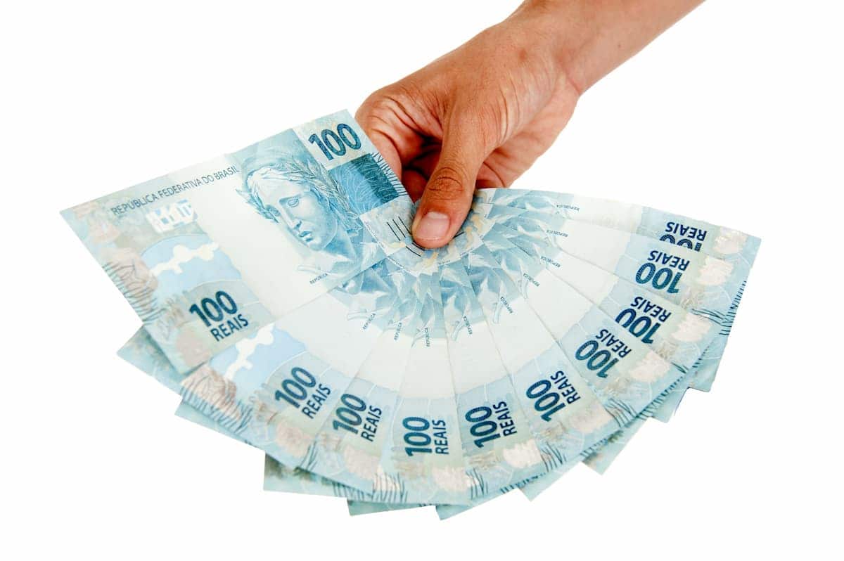 mão com várias notas de 100 abertas em formato de leque