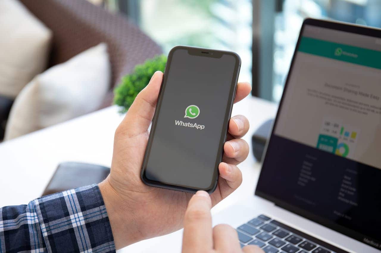 Pessoa segurando celular com aplicativo do WhatsApp aberto