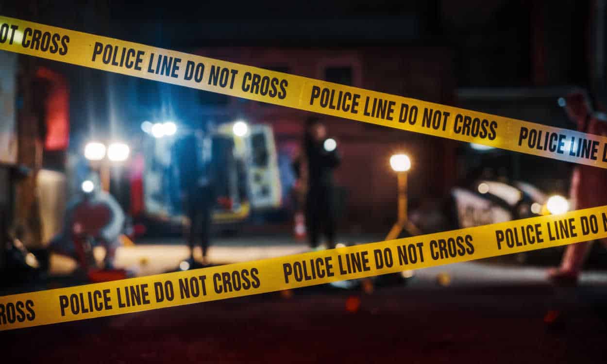 Fita amarela da polícia cercando uma cena de crime
