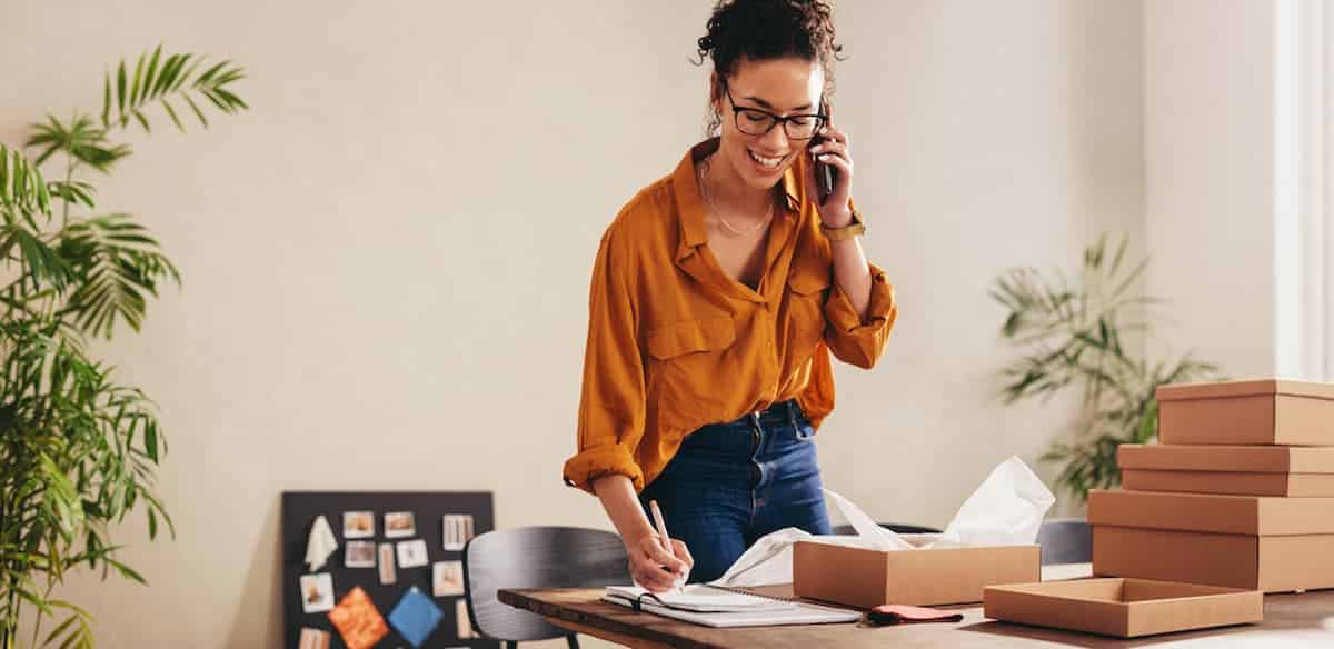 Empreendedora realizando tarefas e ligação telefônica