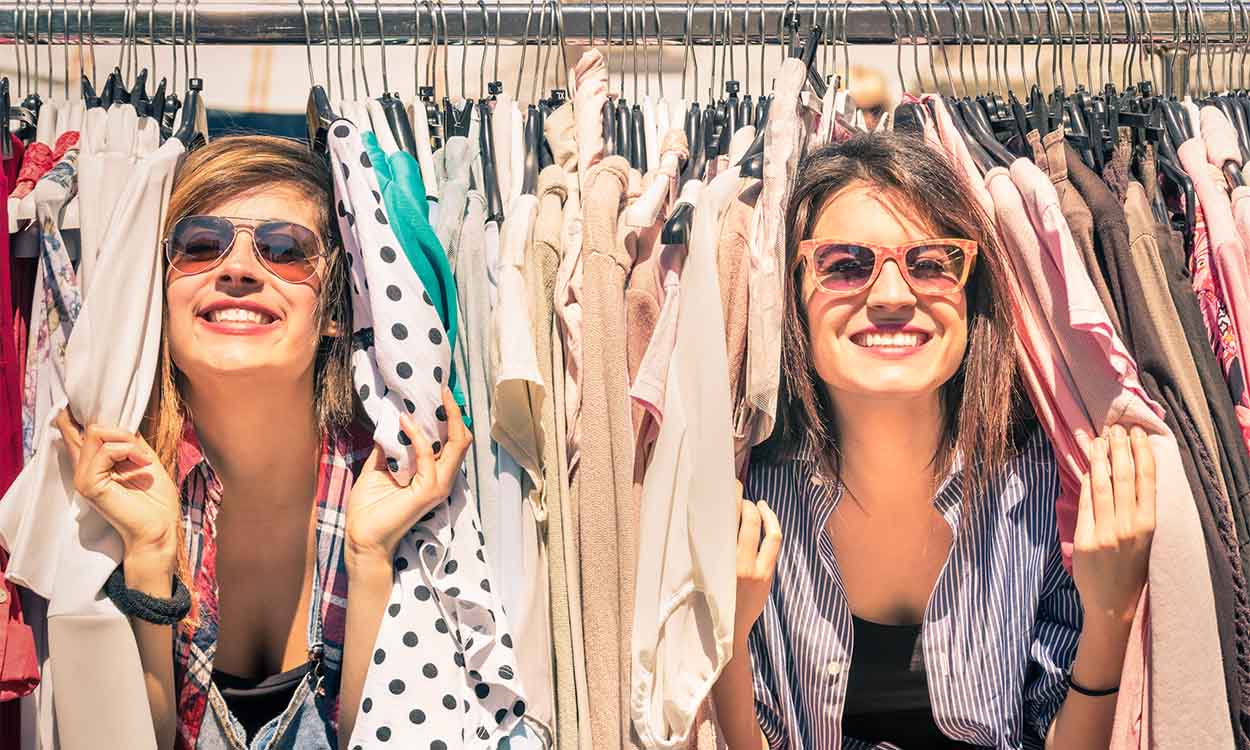 duas mulheres entre roupas em arara