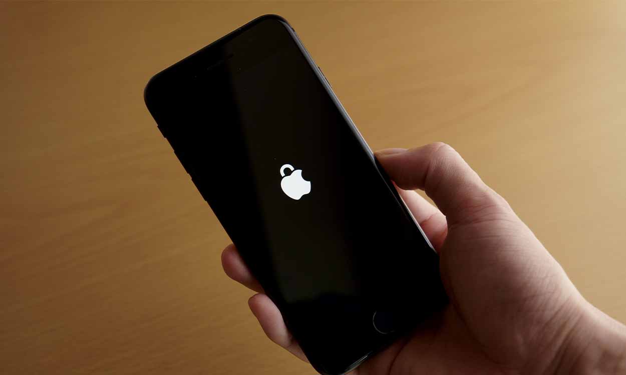 pessoa segurando um Iphone em que o símbolo da Apple parece um cadeado