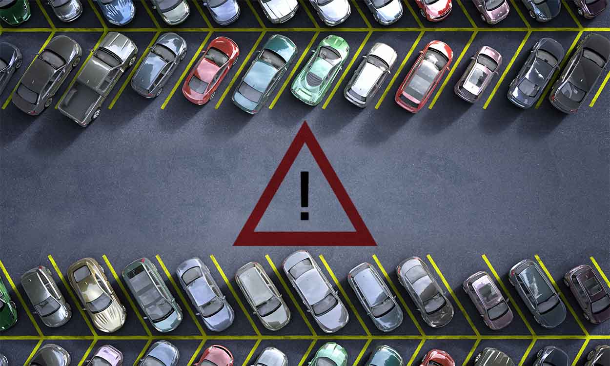 Imagem de estacionamento com um triângulo vermelho com uma exclamação dentro.