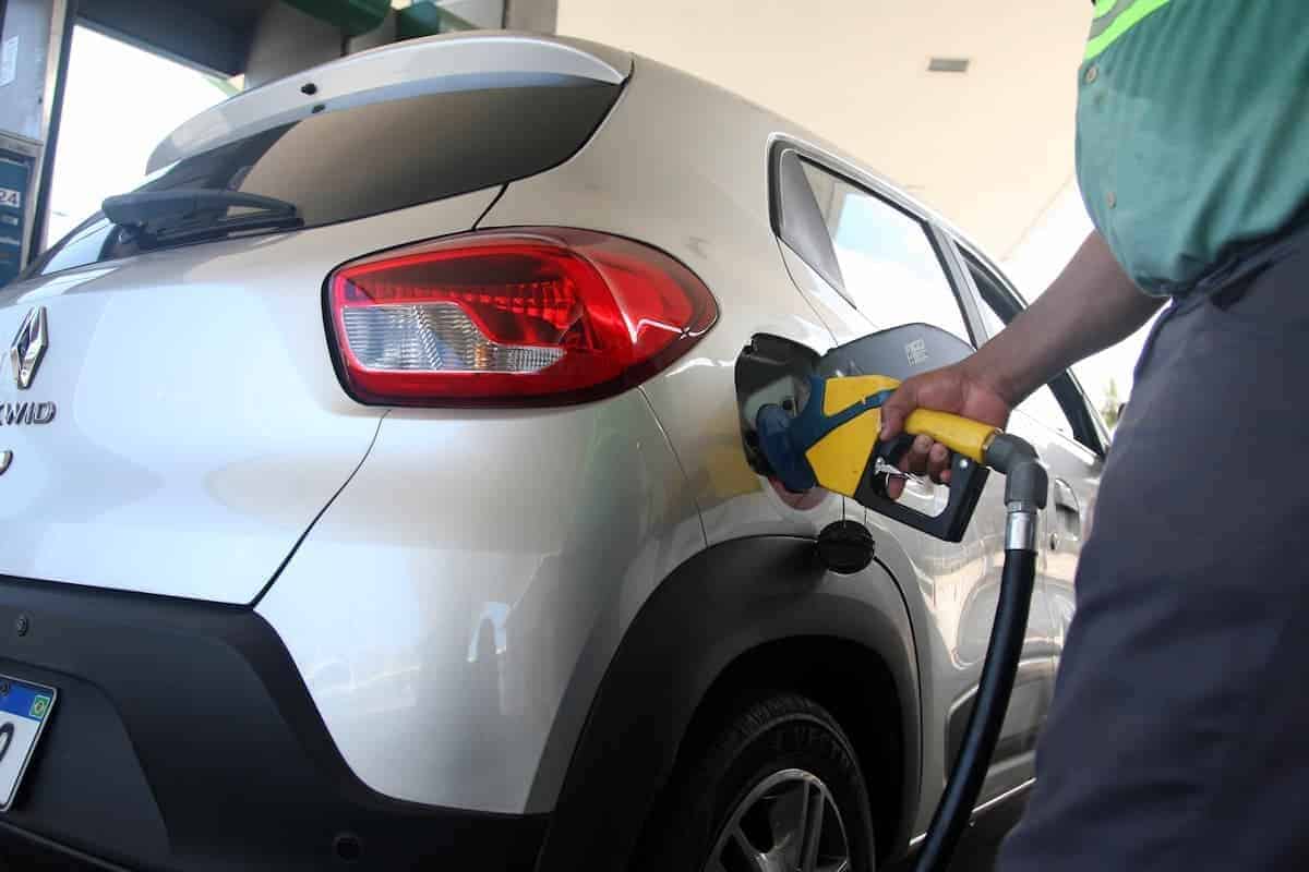 Carro abastecendo gasolina em bomba de posto.
