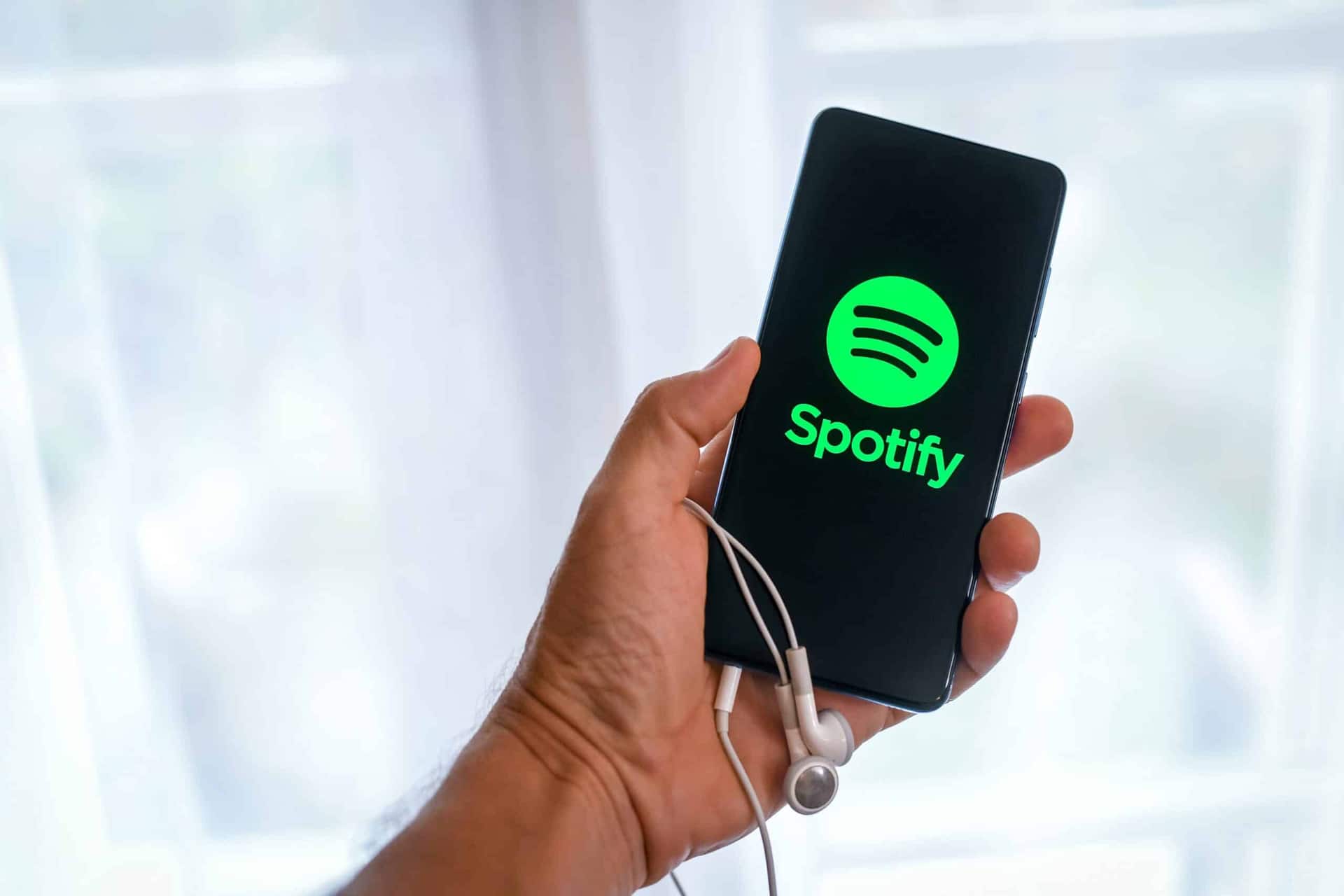mão segurando celular com Spotify