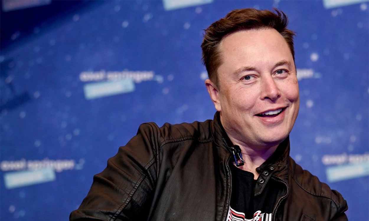 Foto do Elon Musk com expressão alegre e fundo azul