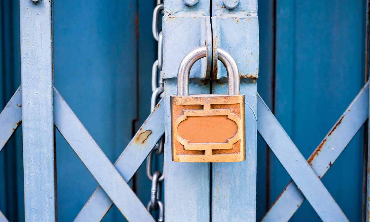 Porta de metal com um cadeado mantendo-a fechada