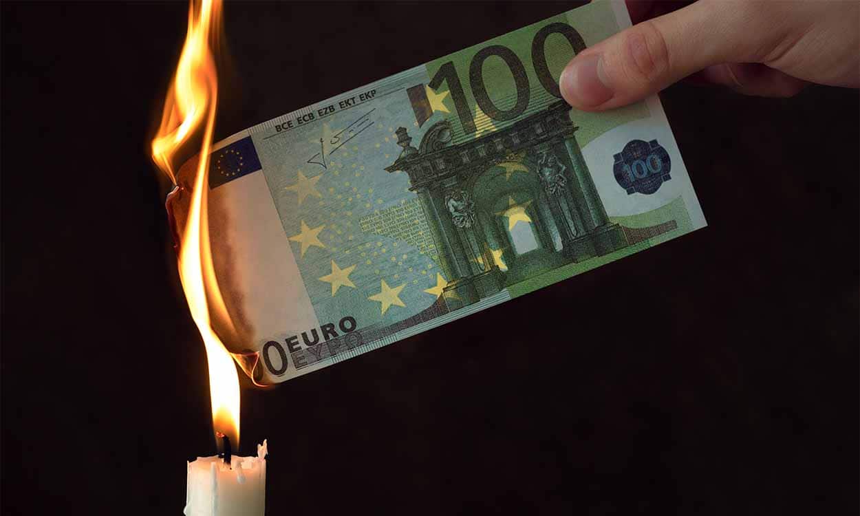 Nota de euro sendo queimada em vela