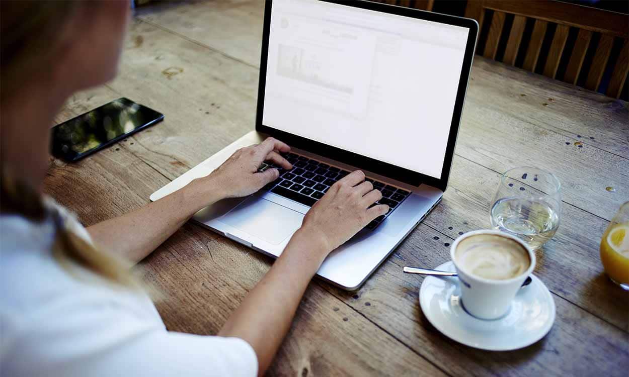 Pessoa mexendo no notebook em uma mesa feriado
