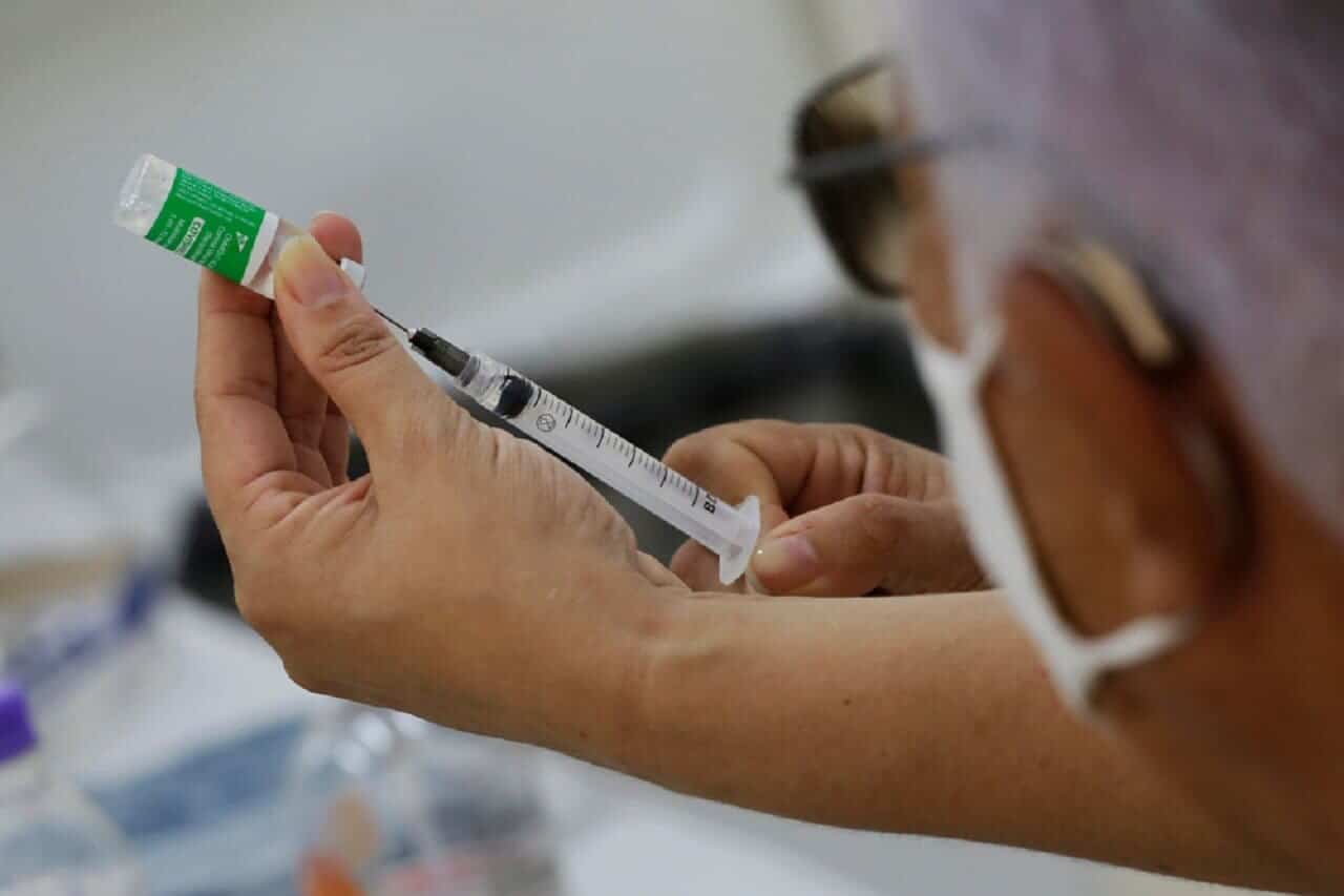 Imagem de um profissional da saúde segurando uma seringa