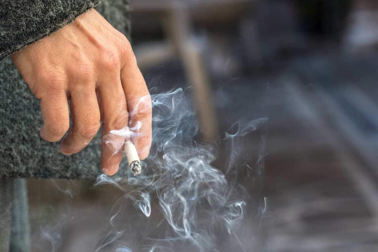 Homem com cigarro queimado na mão
