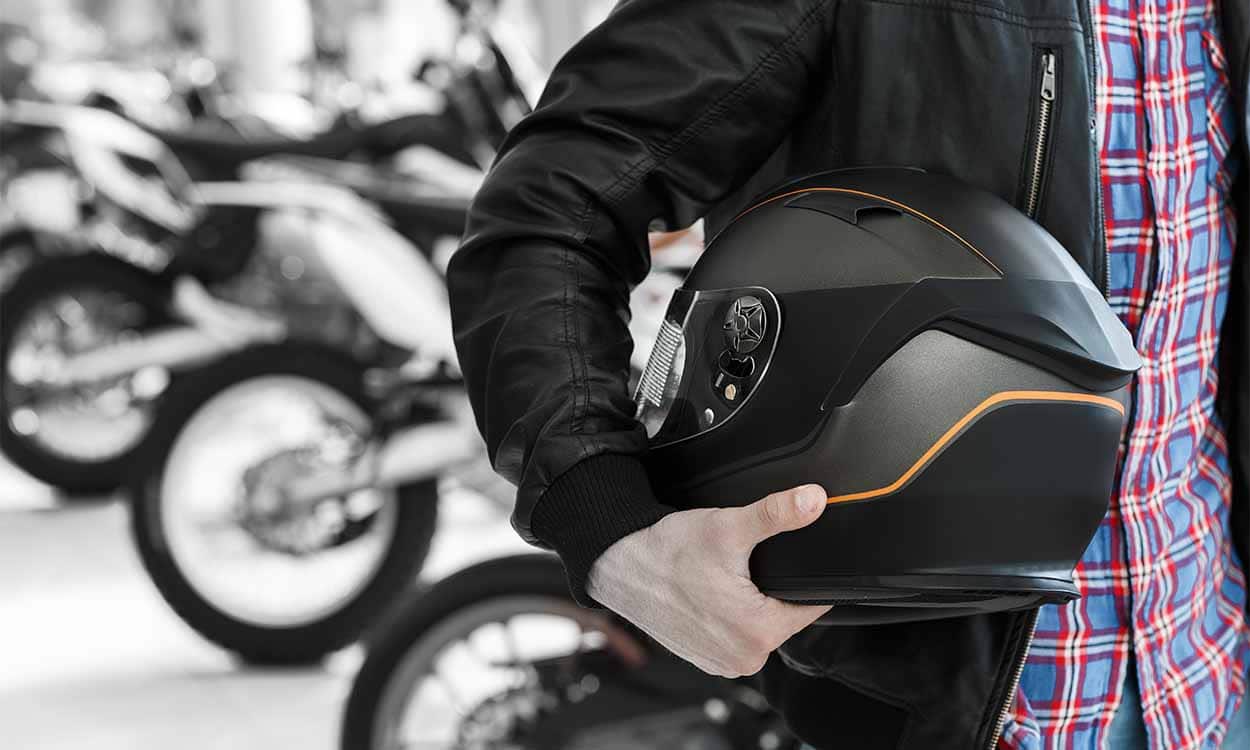 Motoqueiro segurando capacete.