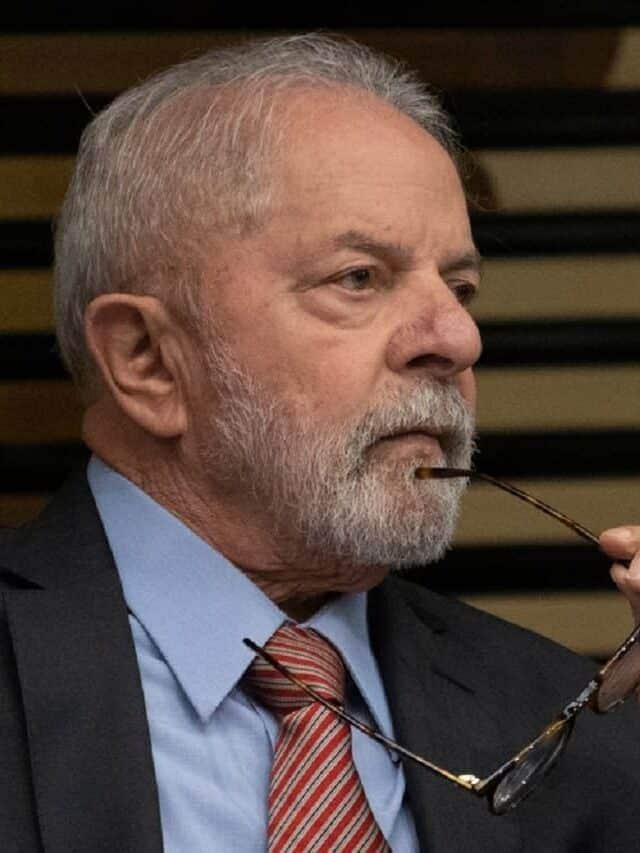 Lula com semblante sério segurando um óculos de grau com a haste dele encostando no queixo, após decidir finalizar o projeto de escolas cívico-militares