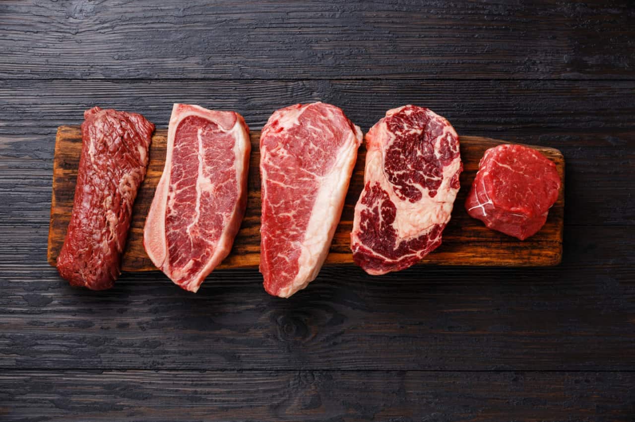 Imagem de diferentes cortes e tipos de carne picanha em uma tábua de madeira