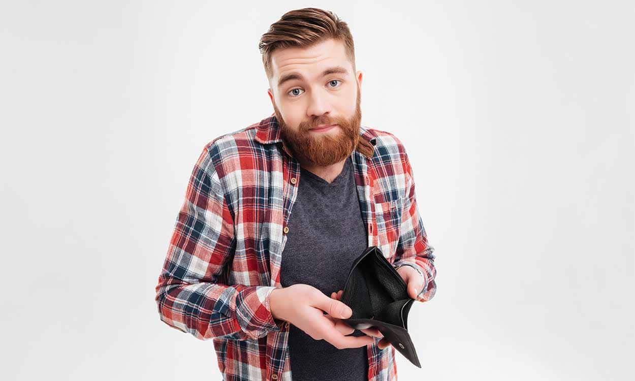 Homem sem reação abrindo carteira vazia precisando de dinheiroImagem: Dean Drobot / shutterstock