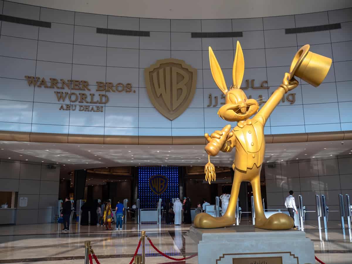 Estátua do Pernalonga, personagem do Looney Tunes, em dourado, em frente ao logo da Warner Bros.