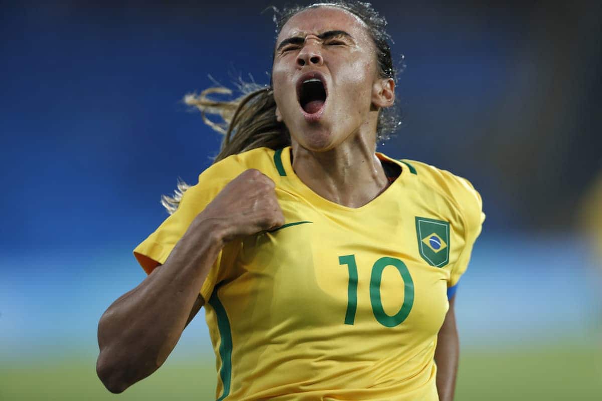 Jogadora Marta comemorando gol vestida com o uniforme da seleção brasileira.