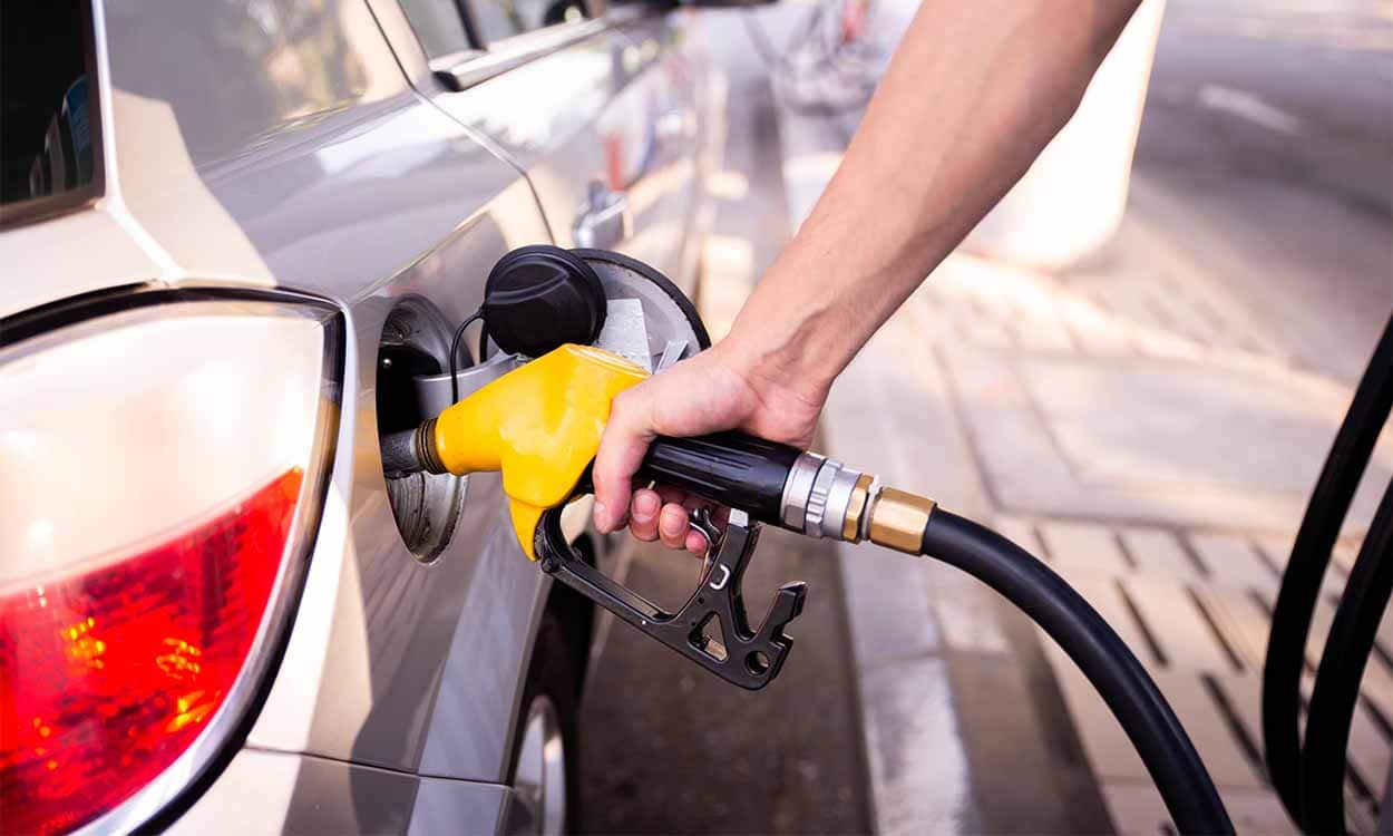 pessoa abastecendo carro com bomba em posto de gasolina