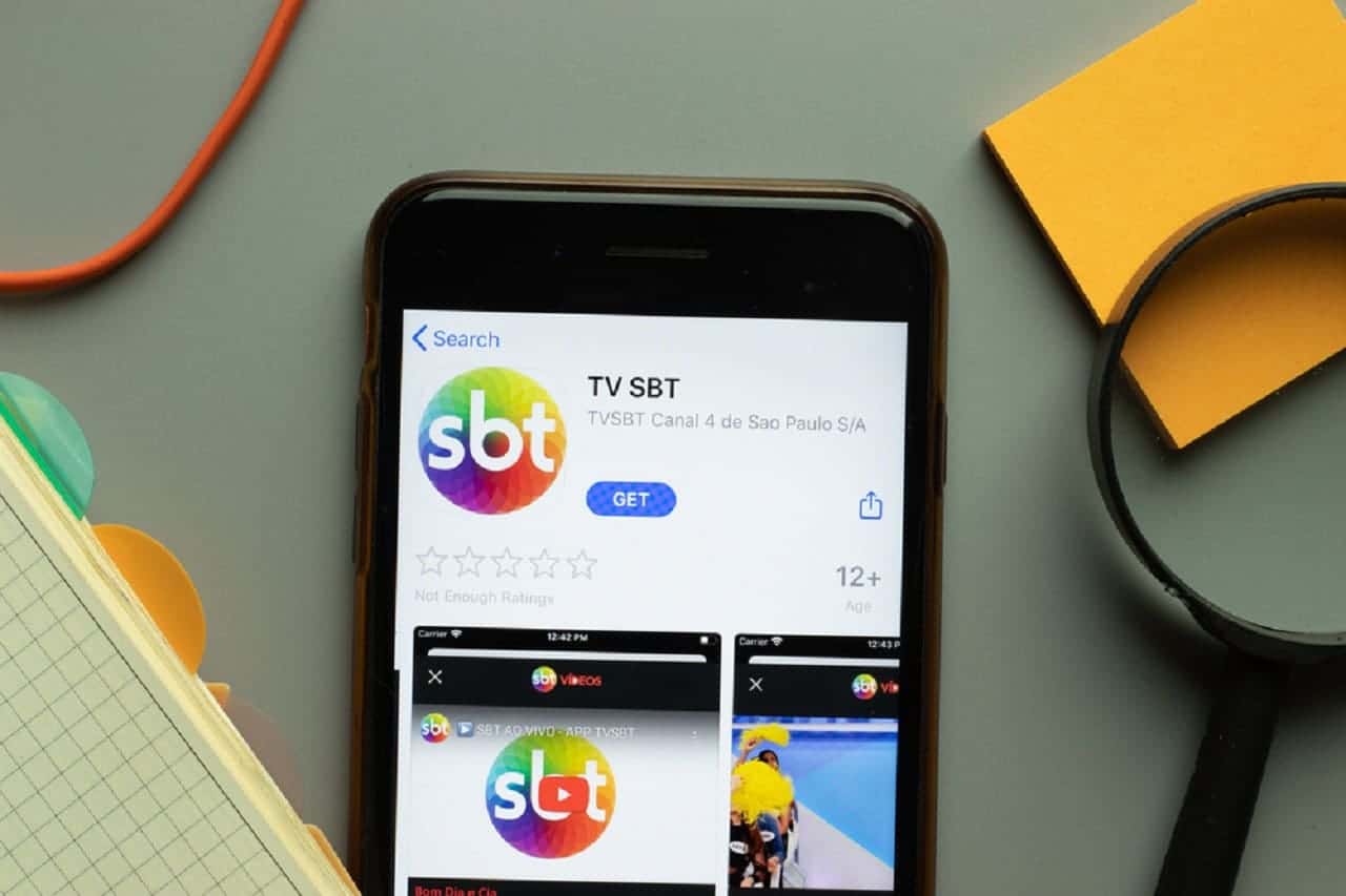 Imagem de um celular com a tela na logo do SBT