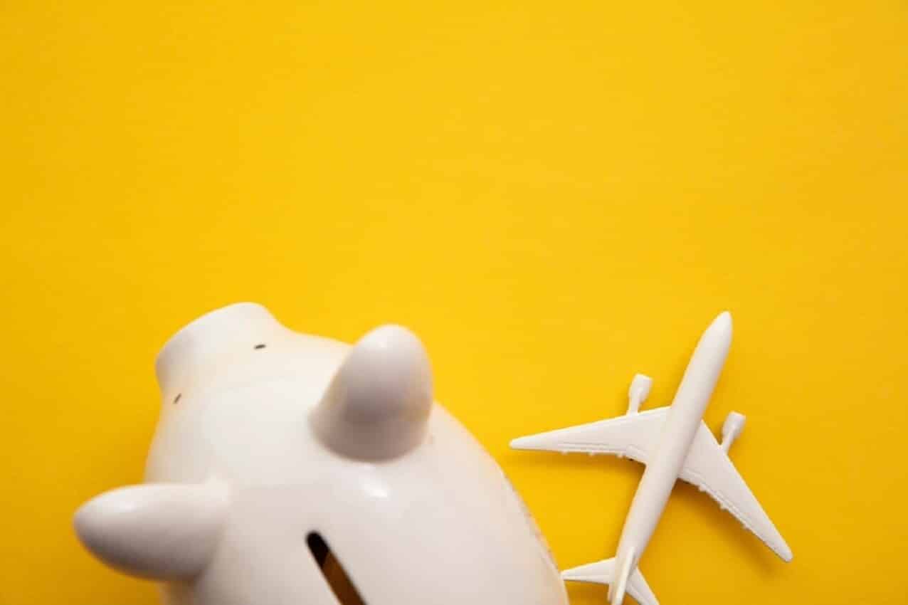 Imagem de um cofre em formato de porco e um avião em miniatura
