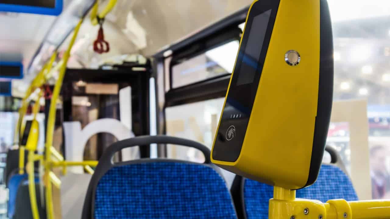 validador de Bilhete Único em ônibus público, ao fundo é possível ver bancos de passageiros que utilizaram do benefício.