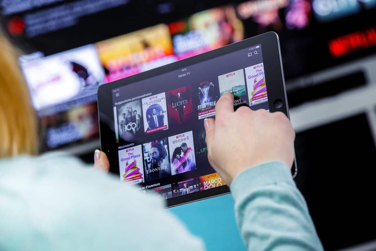 pessoa utilizando um tablet para acessar uma plataforma de streaming