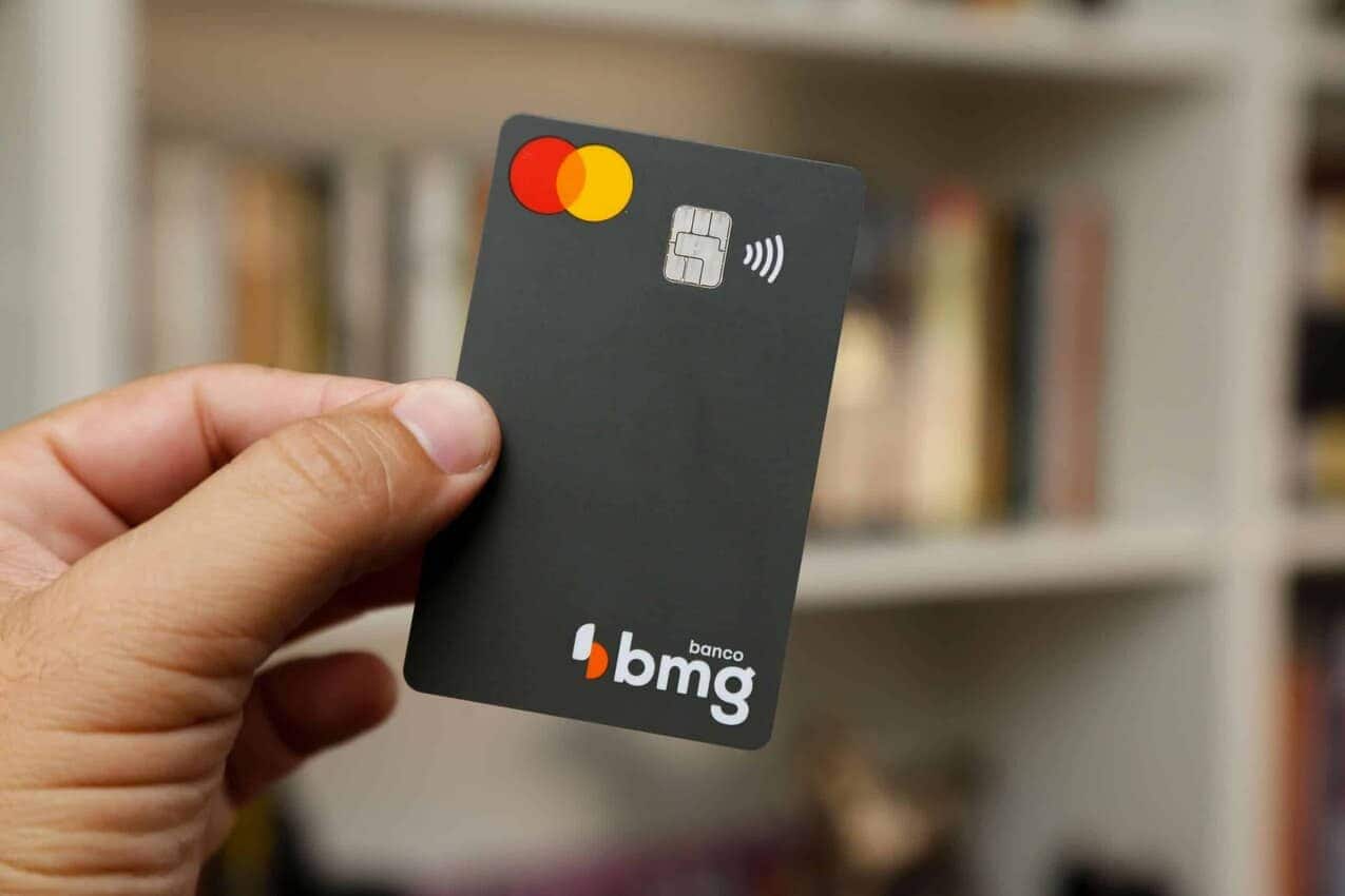 Mão segurando cartão do BMG