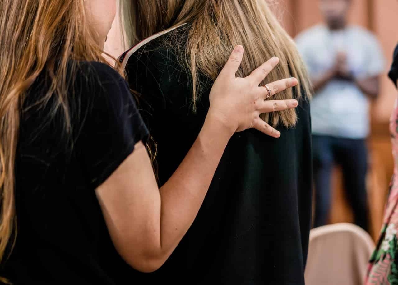 mulheres brancas e loiras fazendo oração em igreja