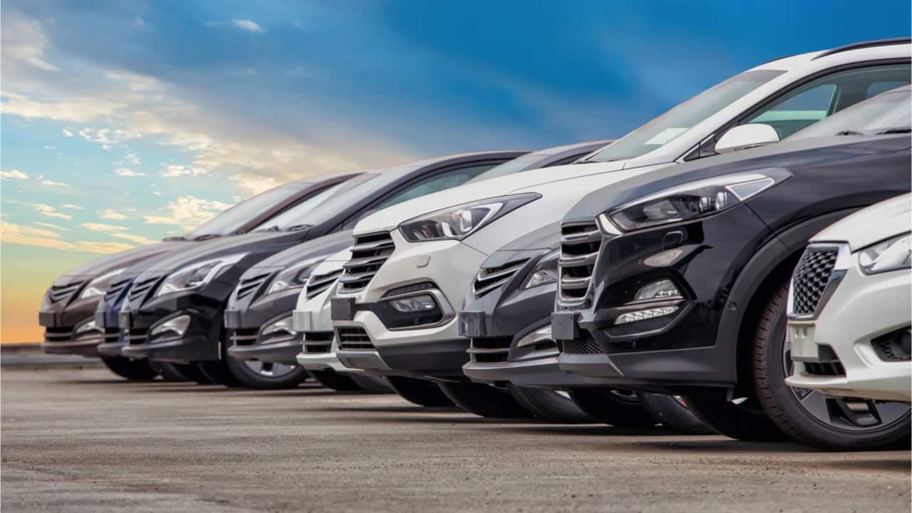 Nove carros enfileirados em um estacionamento