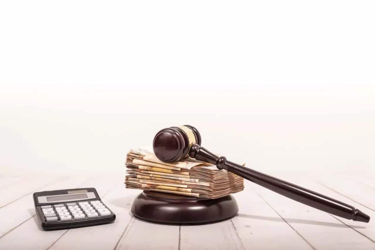 Calculadora, notas de dinheiro e martelo da justiça