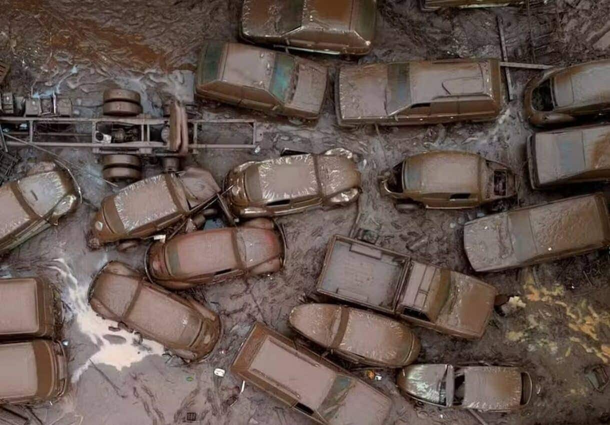 Vários carros cobertos por lama das enchentes do RS