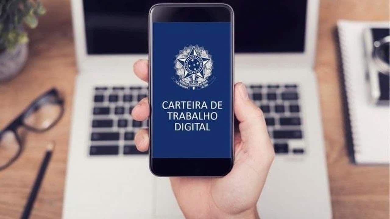 Uma mão segurando um celular com o aplicativo da Carteira de trabalho digital aberta empréstimo