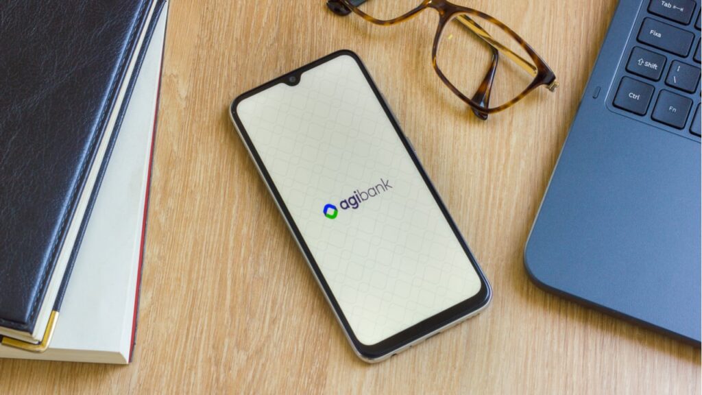 Imagem com um smartphone aberto na pagina do banco Agibank