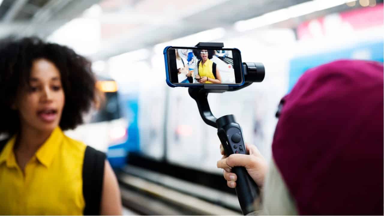 Pessoa filmando mulher em com um celular, simbolizando o ranking dos influenciadores que mais faturam.