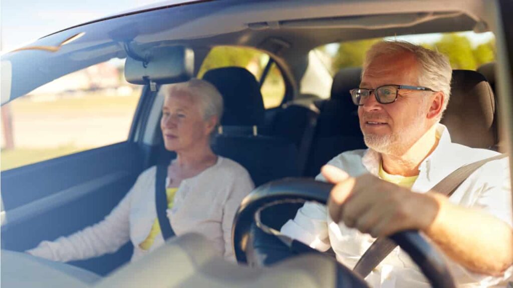 Imagem de um casal de idosos em seu carro