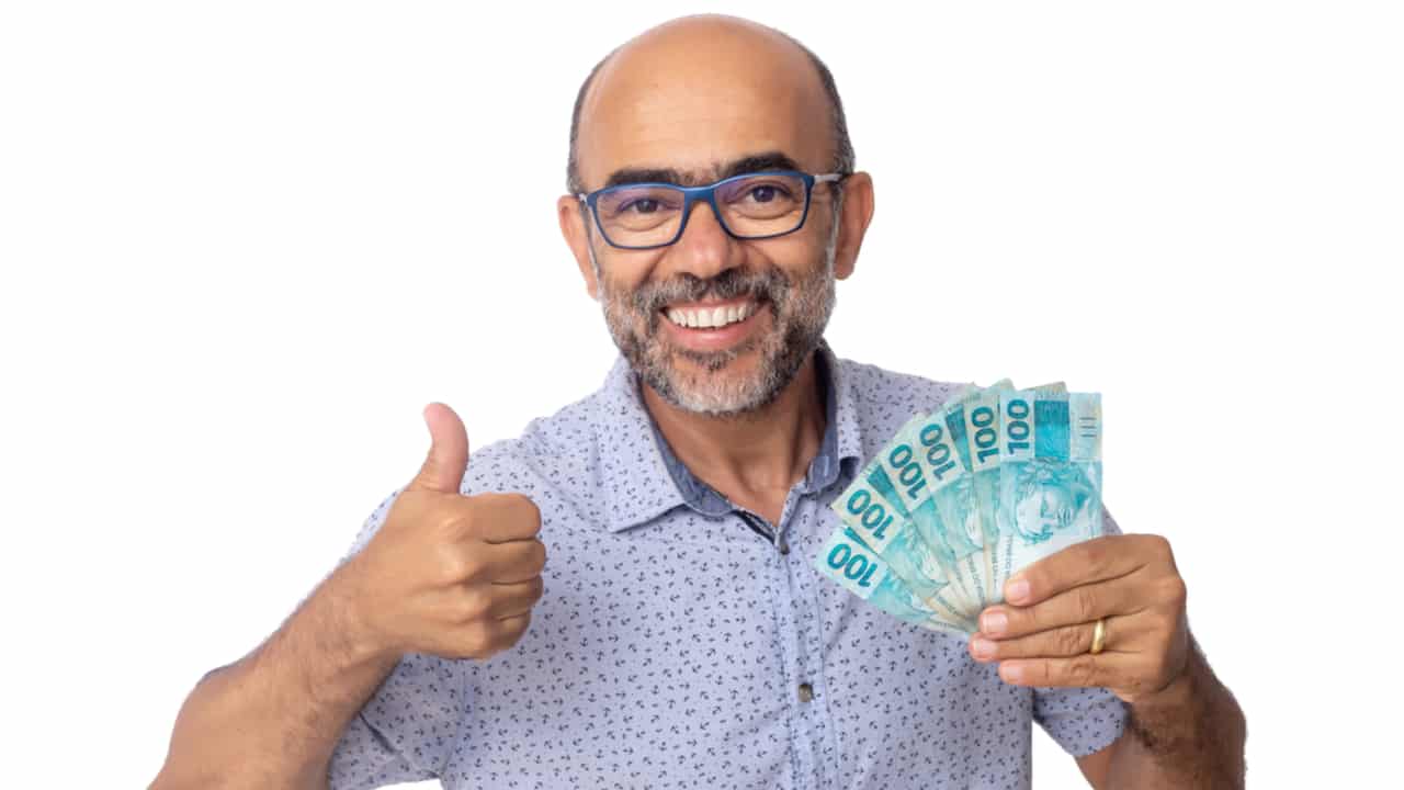 homem sorridente com dinheiro na mão