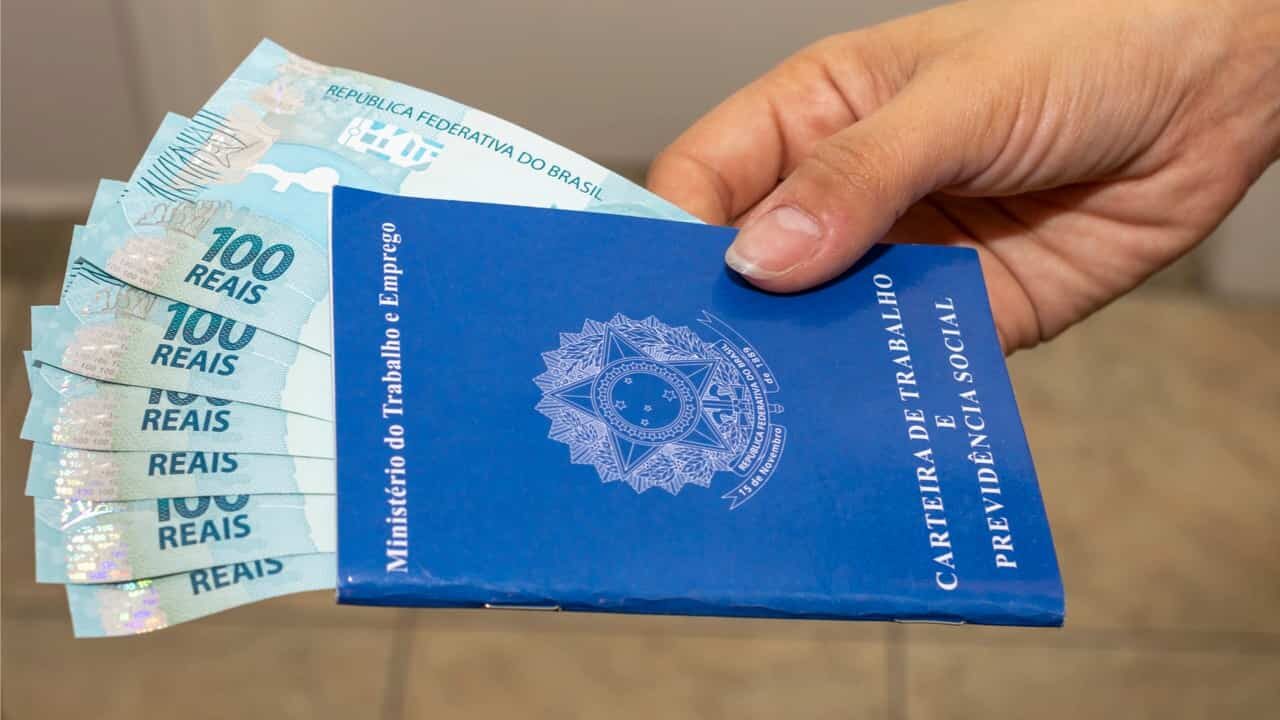 Carteira de trabalho com notas de real