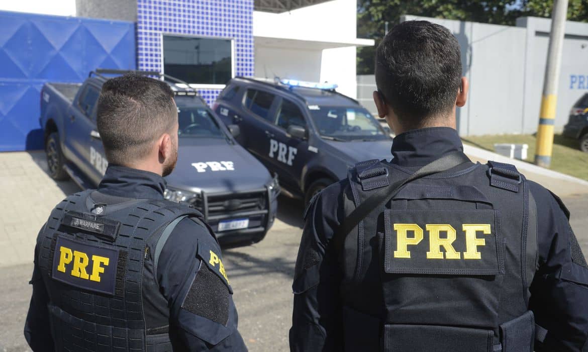 Policial rodoviário federal de costas olhando para estrada