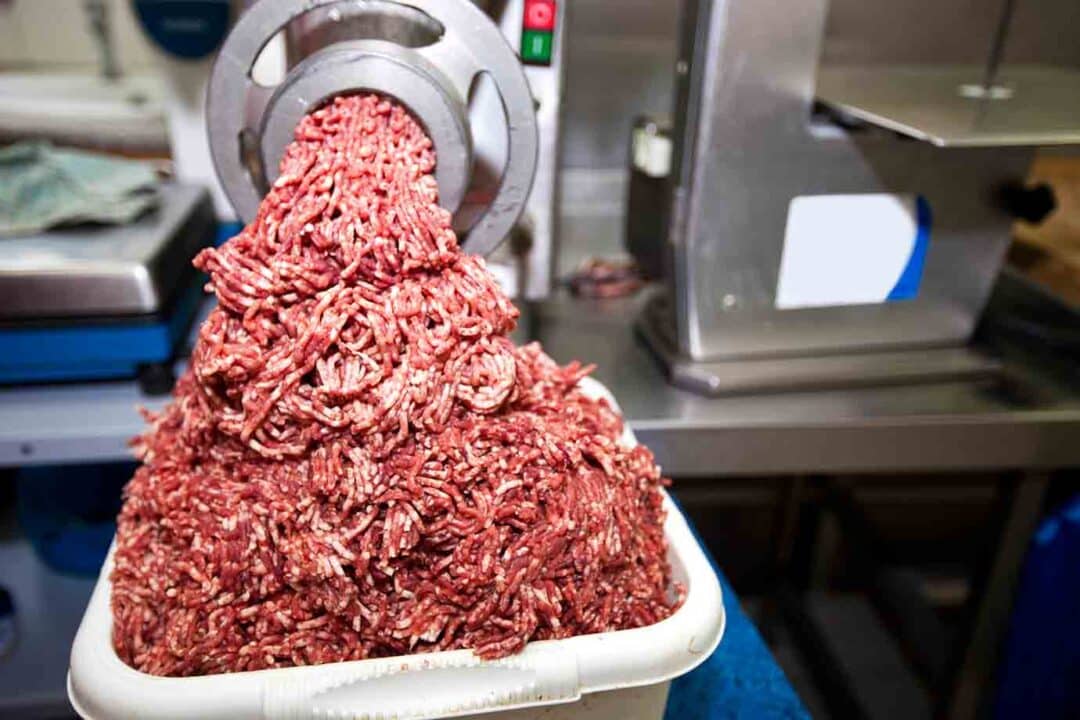 Carne bovina sendo moída em máquina/Reprodução