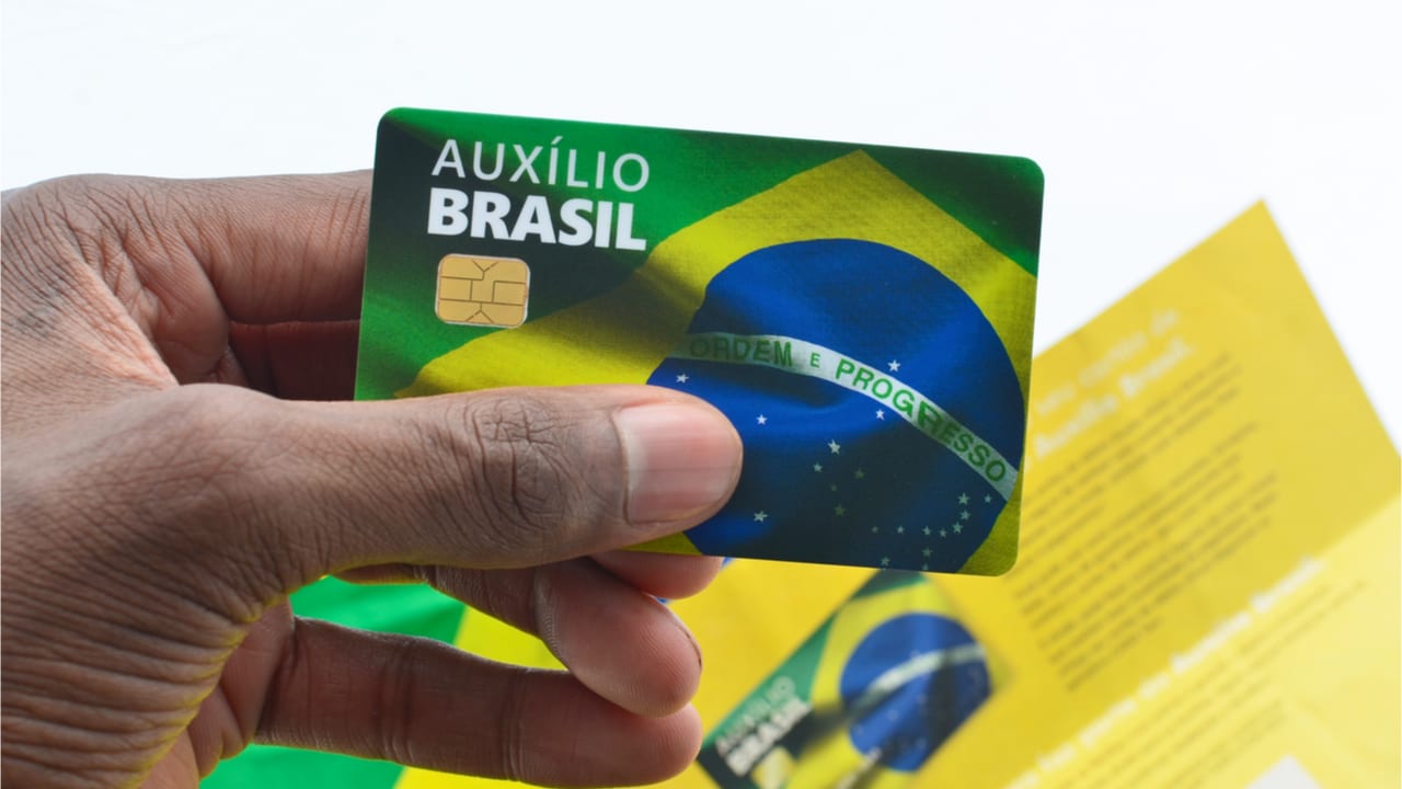 Pessoa segurando o cartão do Auxílio Brasil
