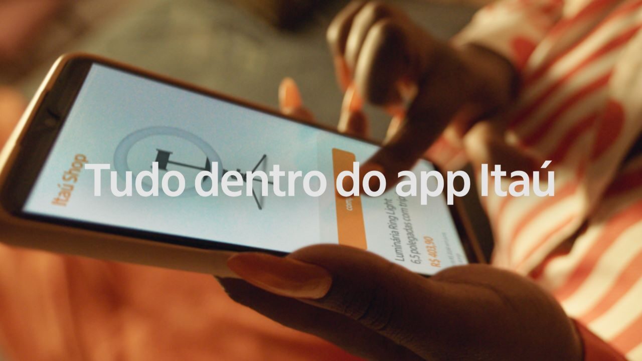 Pessoa utilizando o Itaú Shop no celular. Texto sobre a imagem: "Tudo dentro do app Itaú".